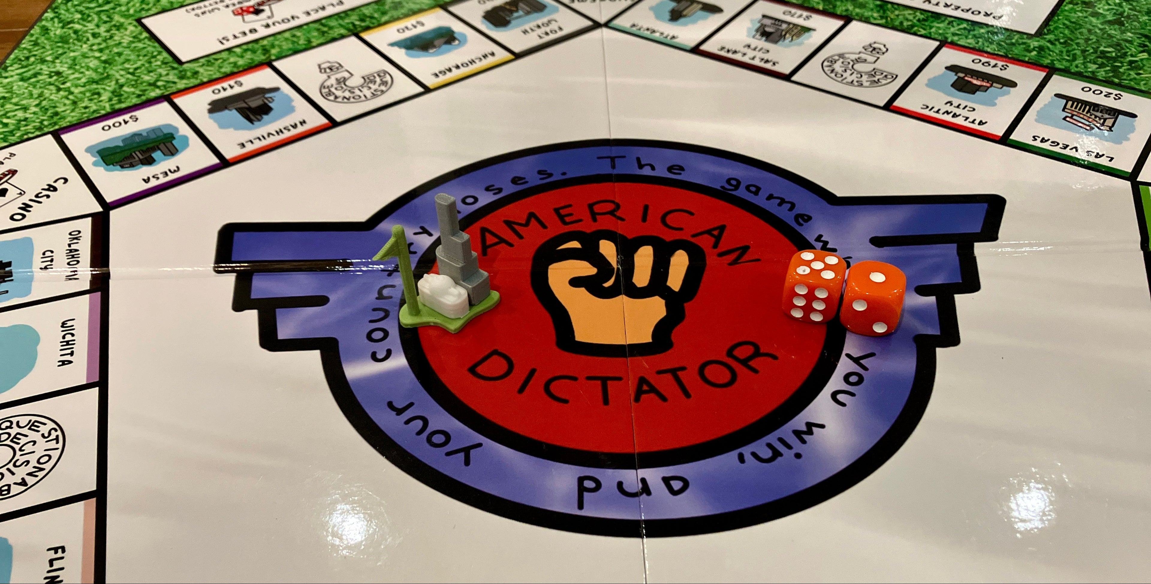 Board game titled 'American Dictator?' with game pieces and dice on a green and white board.